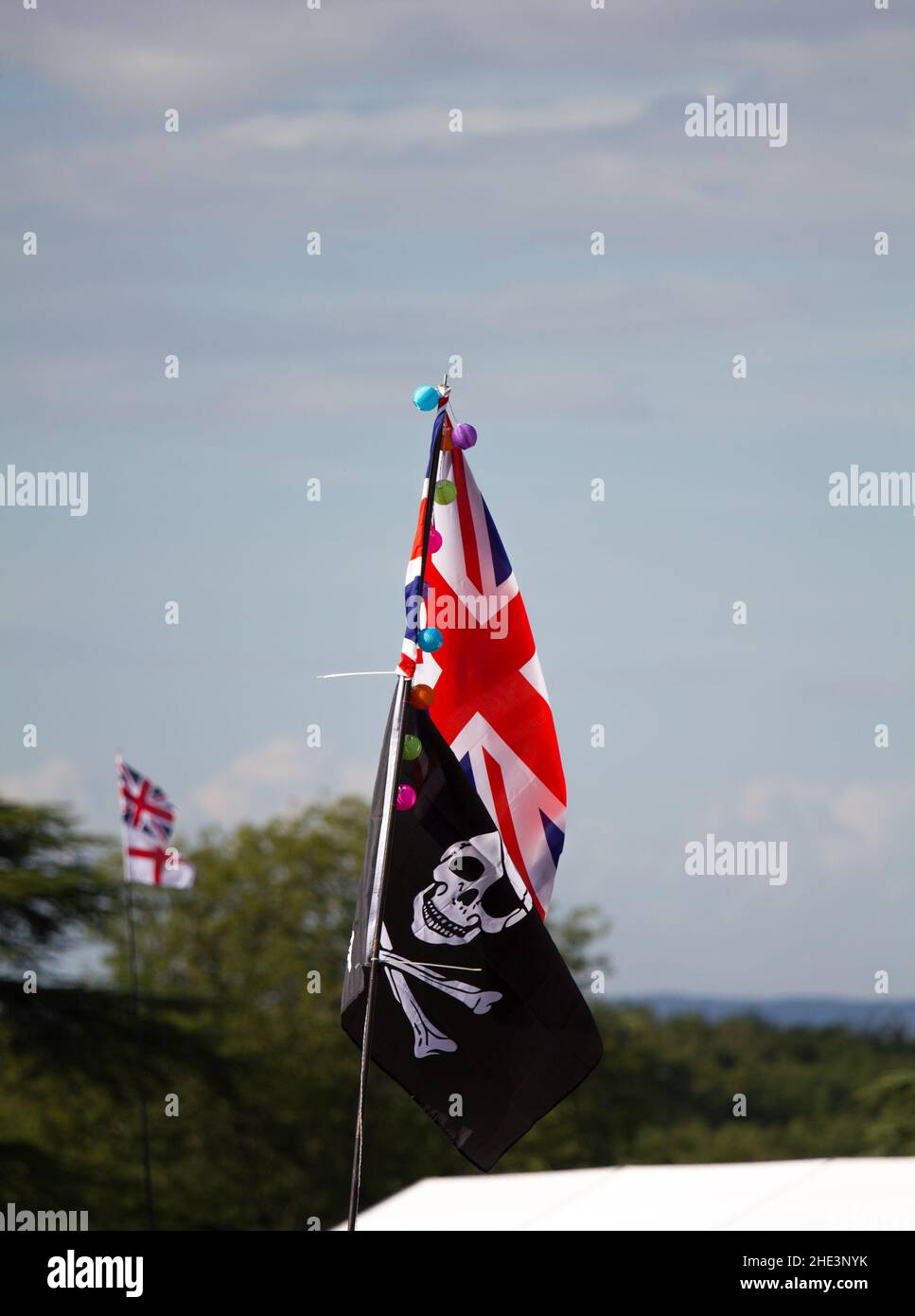 Unionsflagge über einer Piratenflagge von Jolly Roger mit der Flagge von St. George im Hintergrund Stockfoto