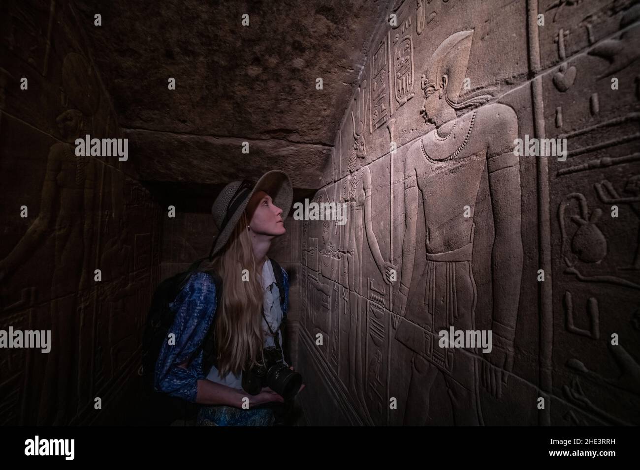 Ein Tourist bewundert die kunstvoll geschnitzten Wände im Philae-Tempelkomplex in Assuan, Ägypten. Stockfoto