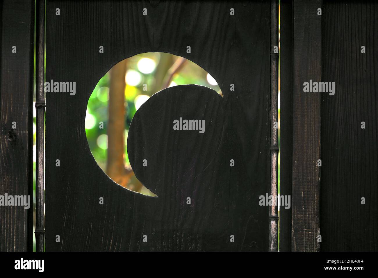Ein Holzzaun mit einer gestempelten Halbmond-Silhouette Stockfoto