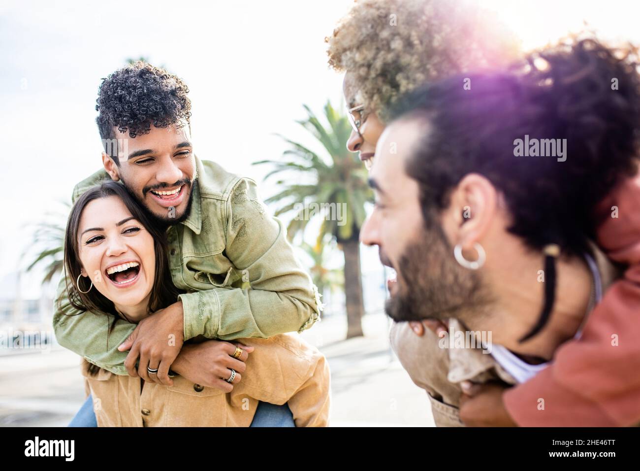 Junge Erwachsene Freunde mit Spaß Huckepack im Freien Stockfoto