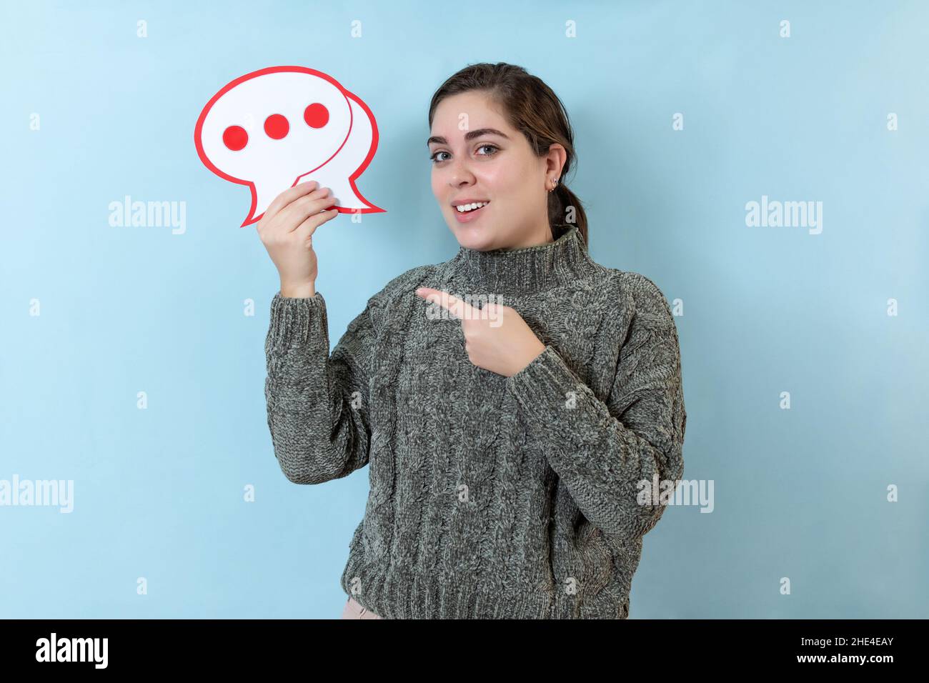 Glückliche junge Frau mit Sprechballon, isoliert über hellblauer Wand. Stockfoto