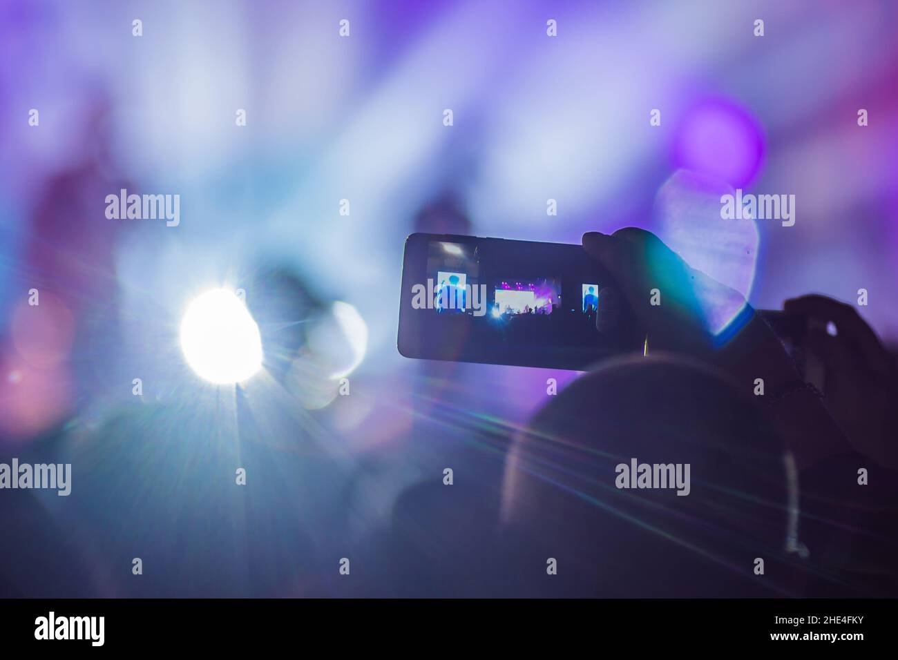 Verwenden Sie Advanced mobile Recording, Spaß Konzerte und schöne Beleuchtung, ehrliches Bild der Masse an Rock Konzert, Nahaufnahme von der Aufnahme von Video mit Smartphone Stockfoto