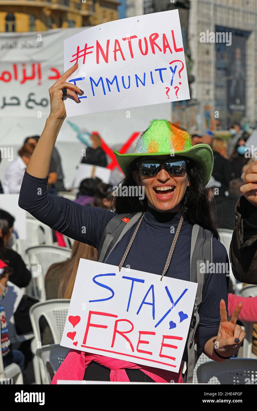 (220109) -- BEIRUT, 9. Januar 2022 (Xinhua) -- Ein Protestler hält am 8. Januar 2022 Plakate auf dem Märtyrerplatz im Zentrum von Beirut, Libanon. Dutzende Libanesen versammelten sich am Samstag auf dem Märtyrerplatz im Zentrum von Beirut, Libanon, um sich gegen Impfungen zu wehren und die Wahlfreiheit zu fordern, während die COVID-19-Fälle im Land immer weiter anstiegen. Unterdessen hat sich die vor drei Wochen im Libanon begonnene COVID-19-Omicron-Welle, die am Samstag landesweit 7.547 neue COVID-19-Fälle registriert hat, in einen „Tsunami“ verwandelt, warnte der Gesundheitsminister des Landes Firas Abiad. Die nationale Zählung lag jetzt bei 769.400, und Stockfoto