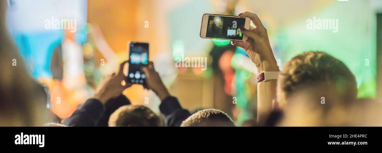 Verwenden Sie Advanced mobile Recording, Spaß Konzerte und schöne Beleuchtung, ehrliches Bild der Masse an Rock Konzert, Nahaufnahme von der Aufnahme von Video mit Smartphone Stockfoto