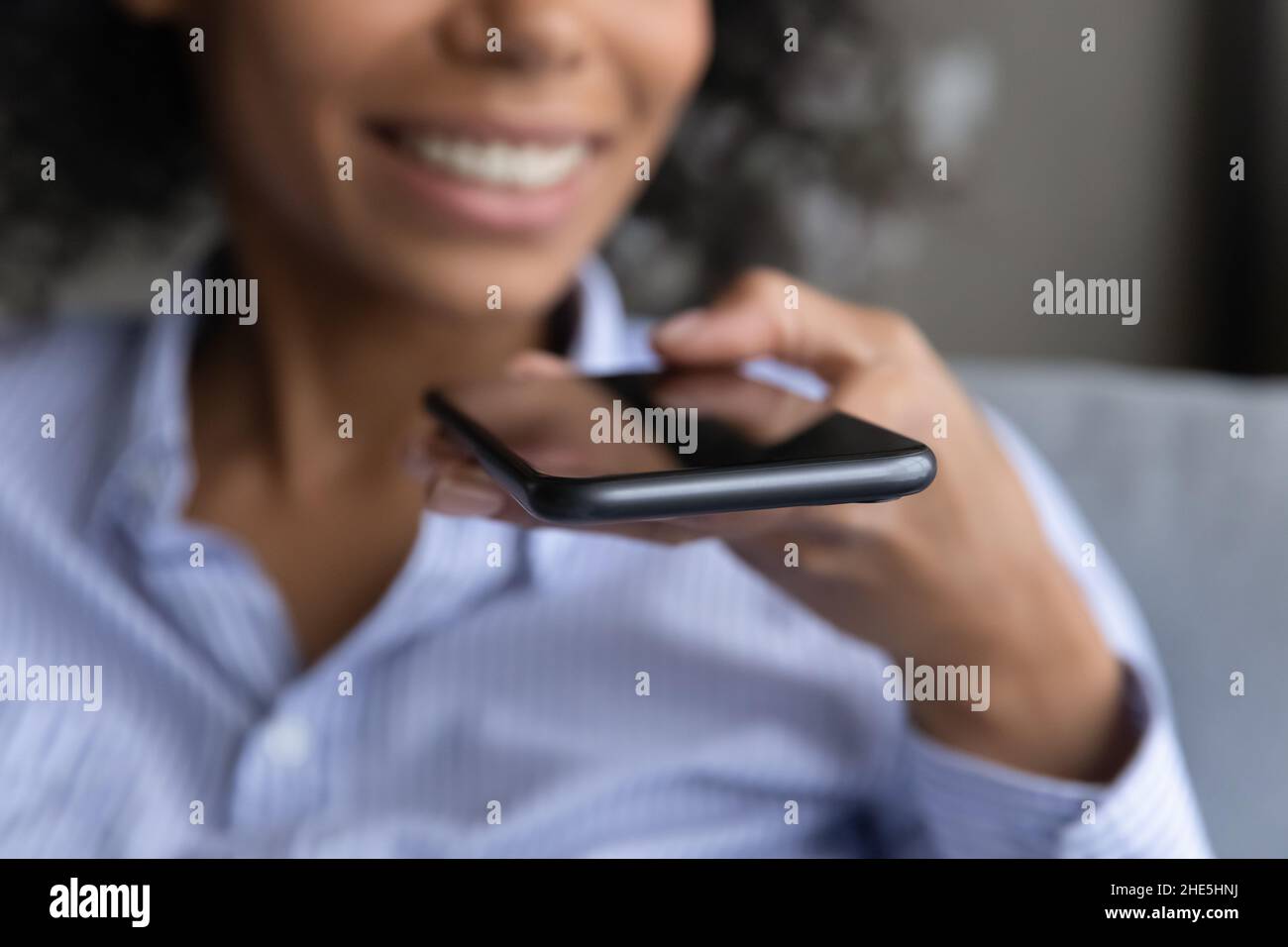Nahaufnahme einer afrikanischen Frau, die Sprachnachrichten aufzeichnet. Stockfoto