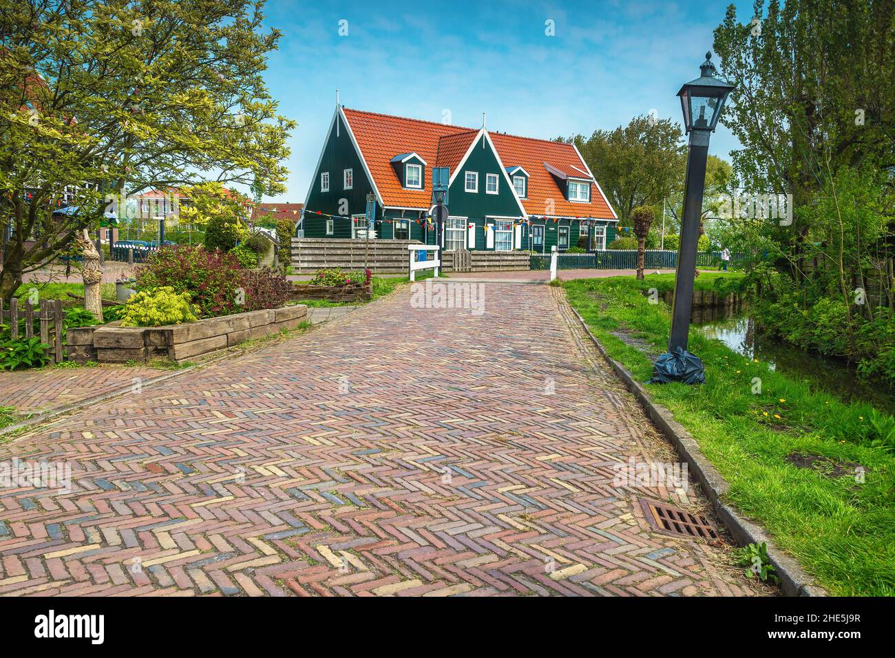 Schöner Blick auf die Straße mit gepflastertem Gehweg und engem Wasserkanal, Marken, Niederlande, Europa Stockfoto