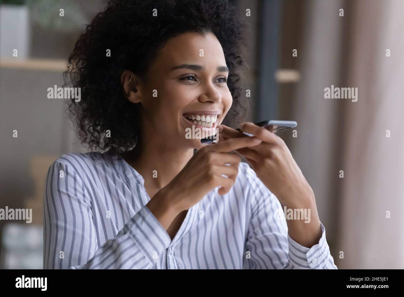 Glücklich attraktive tausendjährige afrikanische Frau Aufnahme Audio-Nachricht. Stockfoto