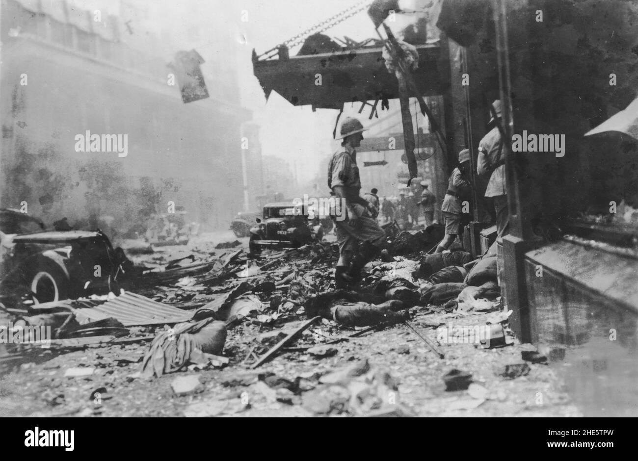 Zweiter Chinesisch-Japanischer Krieg, 1937-1945. Westliche Truppen untersuchen Opfer und Zerstörungen nach dem „Blutigen Samstag“ – einem zufälligen Bombenangriff auf die internationale Siedlung, der von einem chinesischen Flugzeug während der Schlacht von Shanghai am 14th. August 1937 durchgeführt wurde. Stockfoto