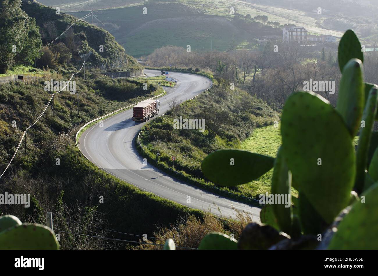 sizilianische Landschaft mit Kaktus Kaktus Kaktus Kaktus Birne und Berg kurvige Straße und LKW Stockfoto