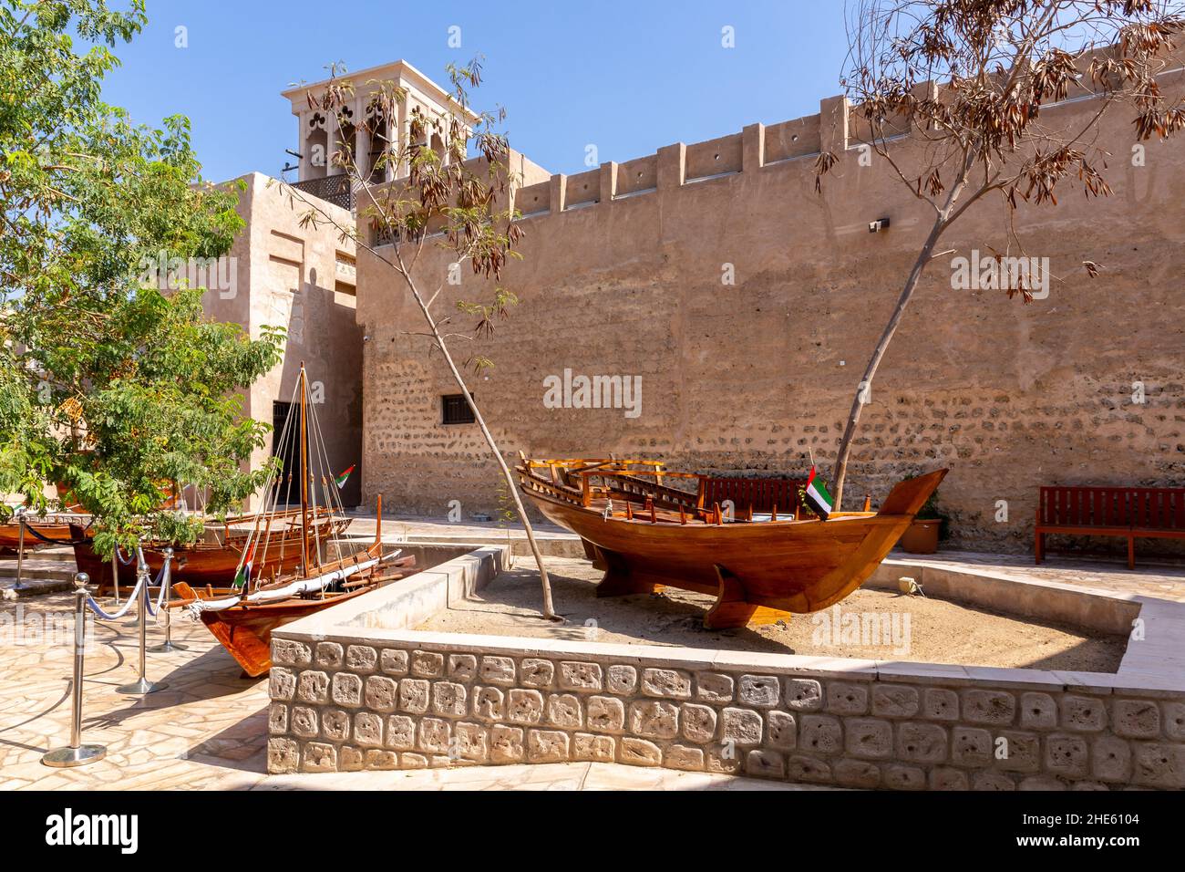 Kleine traditionelle hölzerne Ruderboote - Abras, mit Al Fahidi Old Fort Mauern im Hintergrund, Al Fahidi Historical District, Dubai, United Arab EMI Stockfoto