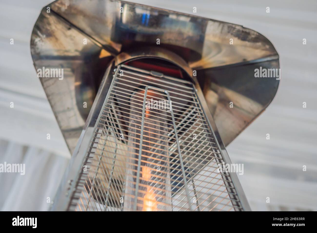 Heizlampe heizofen zwischen den Tischen eines offenen Cafe platziert Stockfoto