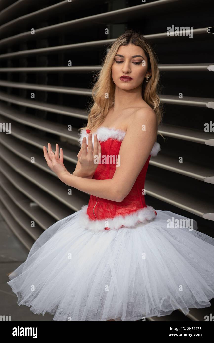 Ballerina trägt High Heels und weihnachtskleid posiert im Freien Stockfoto