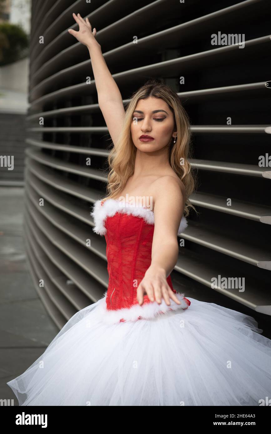 Ballerina trägt weißes und rotes weihnachtsballettkleid, das im Freien tanzt Stockfoto