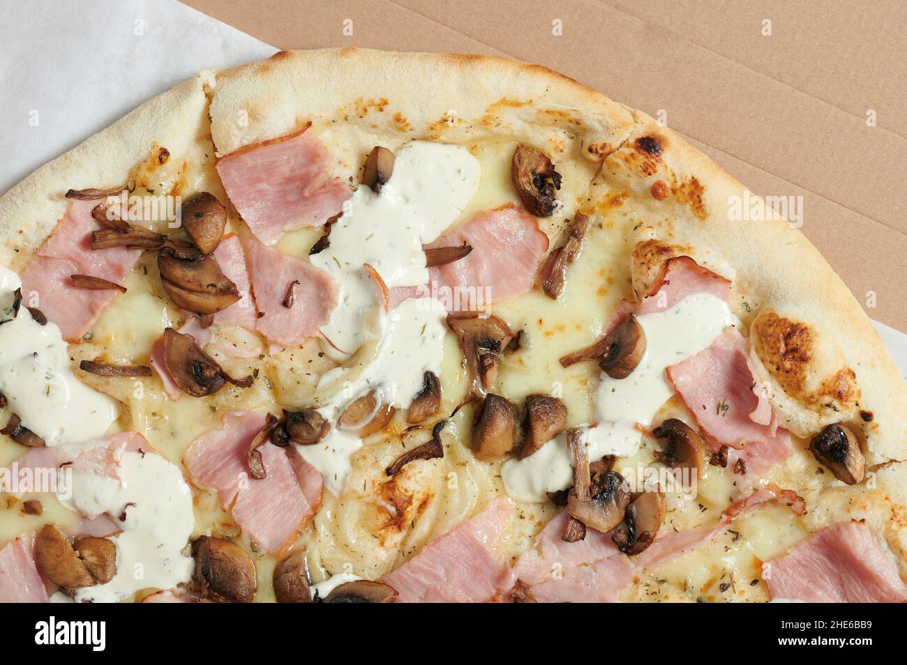 Leckere Pizza mit Schinken und Pilzstückchen oben Ansicht aus nächster Nähe Stockfoto