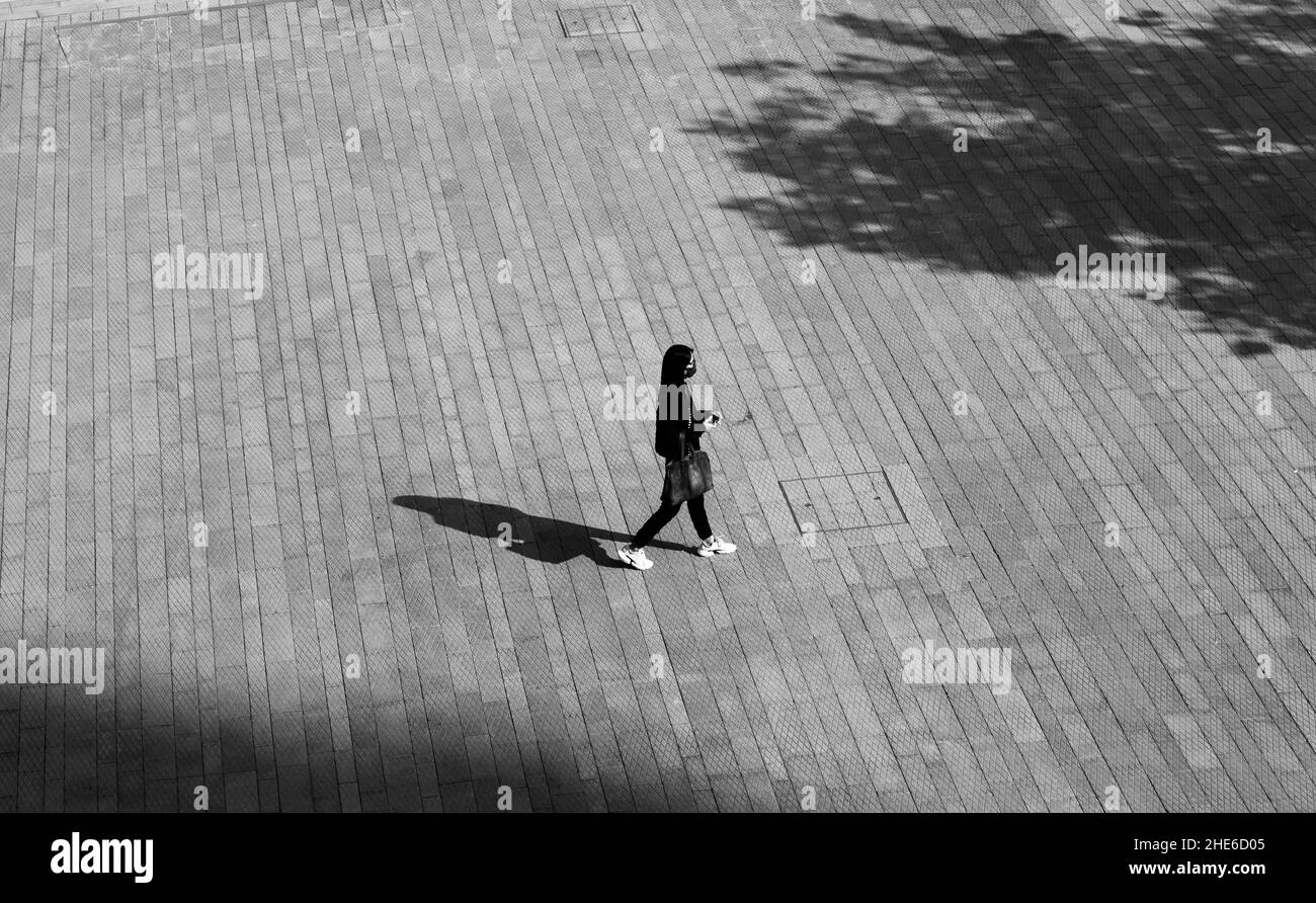Ein Mädchen ist allein auf einem Platz in Central, Hongkong Stockfoto