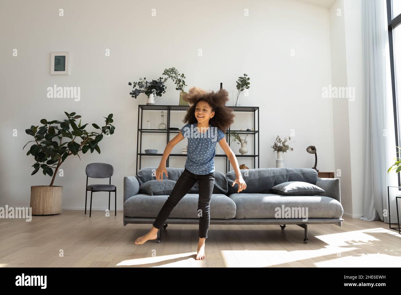 Fröhliche niedliche afroamerikanische Mädchen tanzen zu Hause Musik Stockfoto