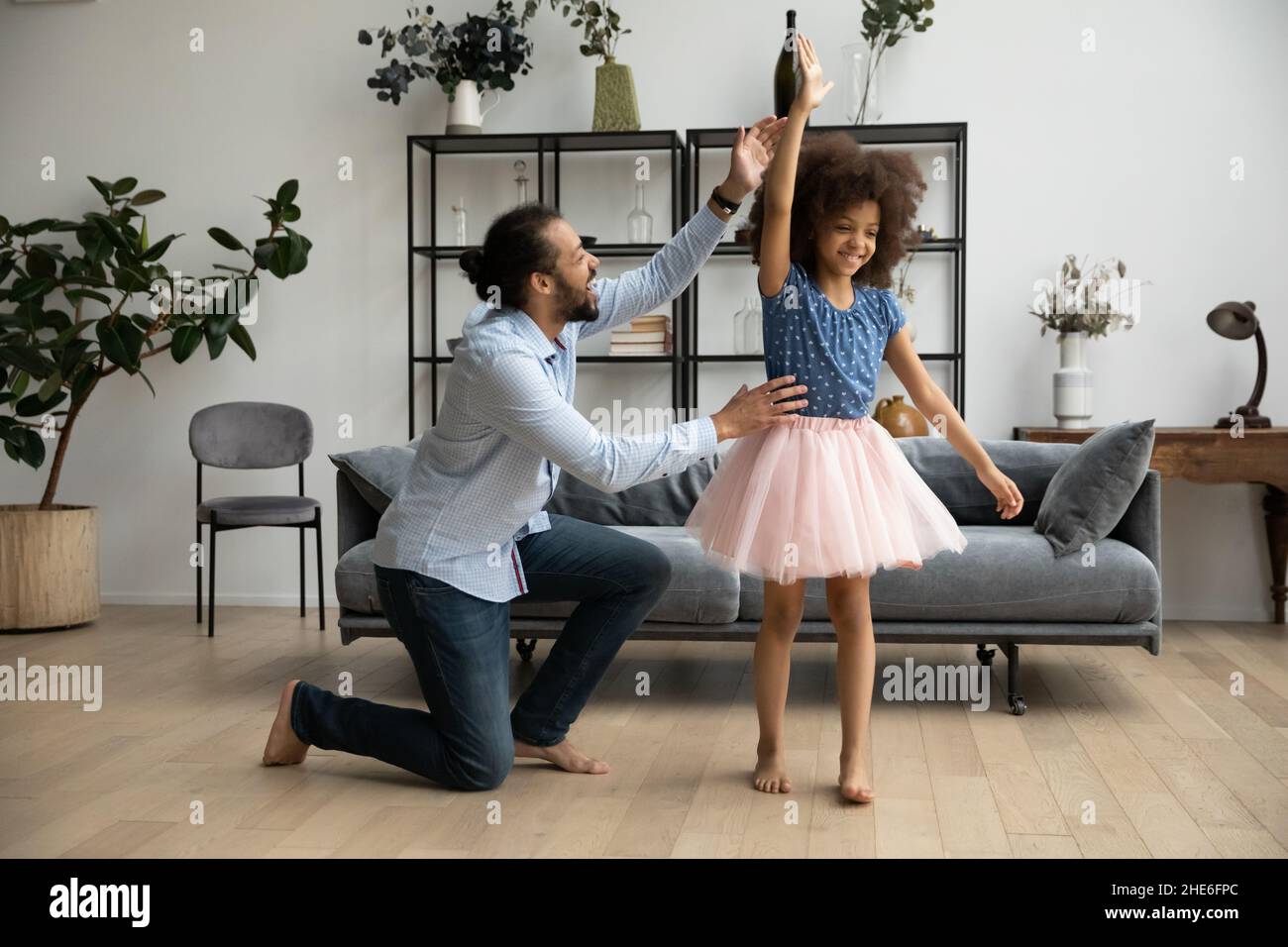 Fröhlicher Vater unterstützt Tochter in Ballerina Rock, Tanz zu lernen Stockfoto
