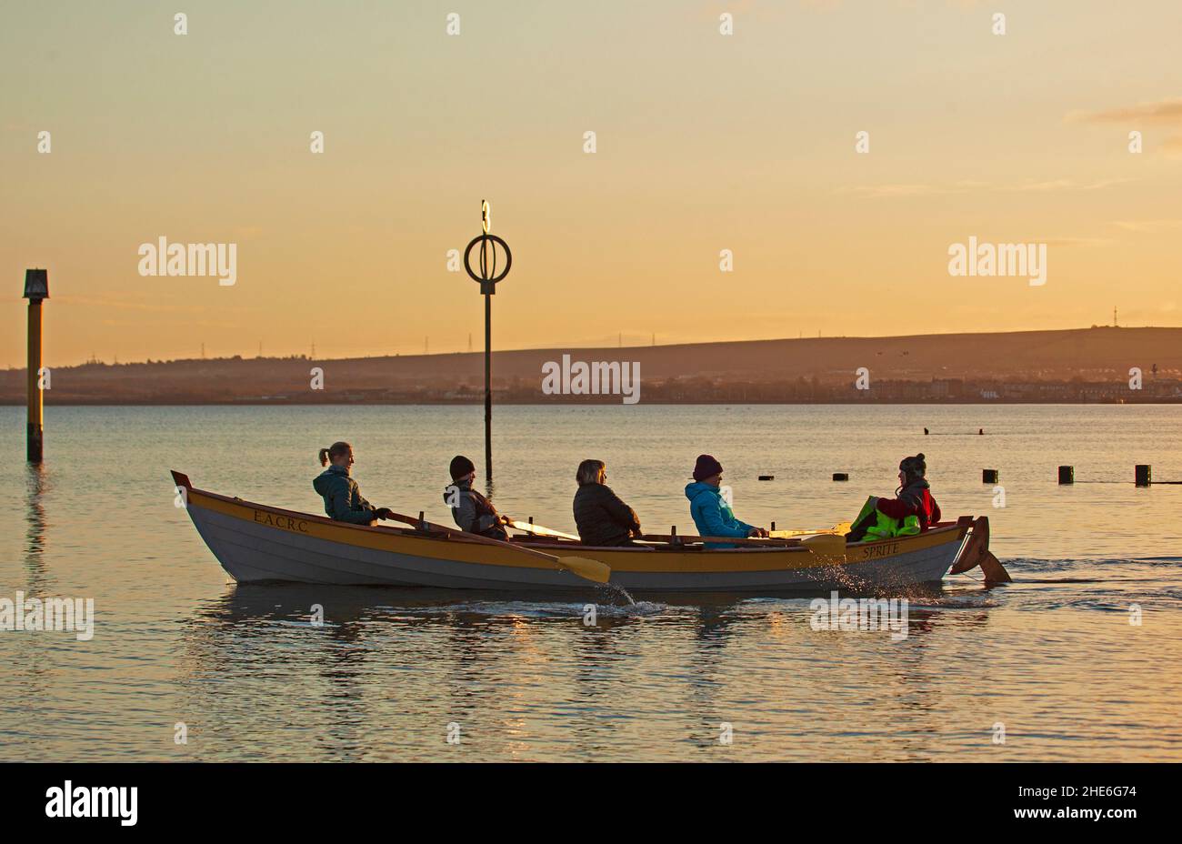 Portobello, Edinburgh, Schottland, Großbritannien 9th. Januar 2022. Kühler, heller Sonnenaufgang, Temperatur von 4 Grad Celsius für diejenigen, die am Strand und am Firth of Forth trainieren. Im Bild: Die Crew des Eastern Amateur Coastal Rowing Club des Sprite macht sich auf den Weg zum Training. Kredit: Archwhite/Alamy Live Nachrichten.. Stockfoto