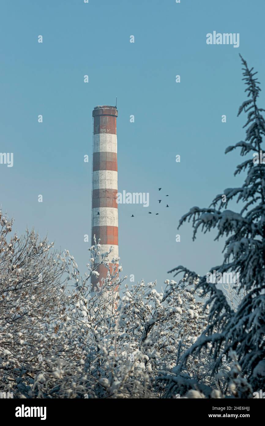 Industrieller alter hoher Ziegelkamin ohne Rauch, am blauen Himmel an einem frostigen Tag in Bulgarien. Stockfoto