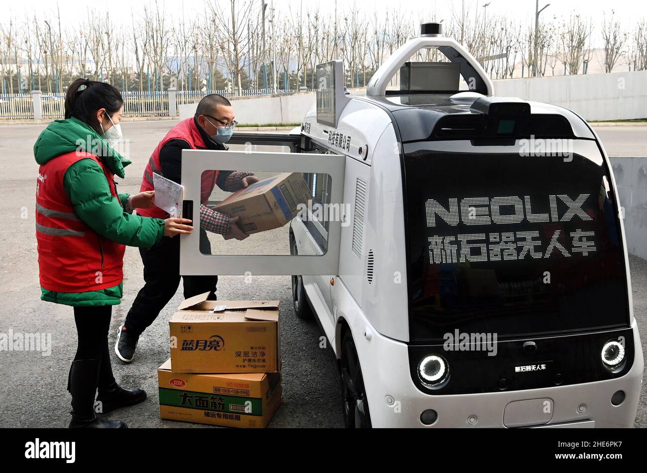 XI'an, Chinas Provinz Shaanxi. 9th Januar 2022. Ein Mitarbeiter lädt ein unbemanntes Lieferfahrzeug mit Waren in Xi'an, der Hauptstadt der nordwestlichen Provinz Shaanxi, ein, 9. Januar 2022. Das fahrerlose Fahrzeug ist für den Transport von Gütern mit einem maximalen Gewicht von 320 kg pro Fahrt ausgelegt. Er kann auf einer einzigen Fahrt 6,5 km durch die Fahrspuren auf Straßen fahren. Quelle: Tao Ming/Xinhua/Alamy Live News Stockfoto