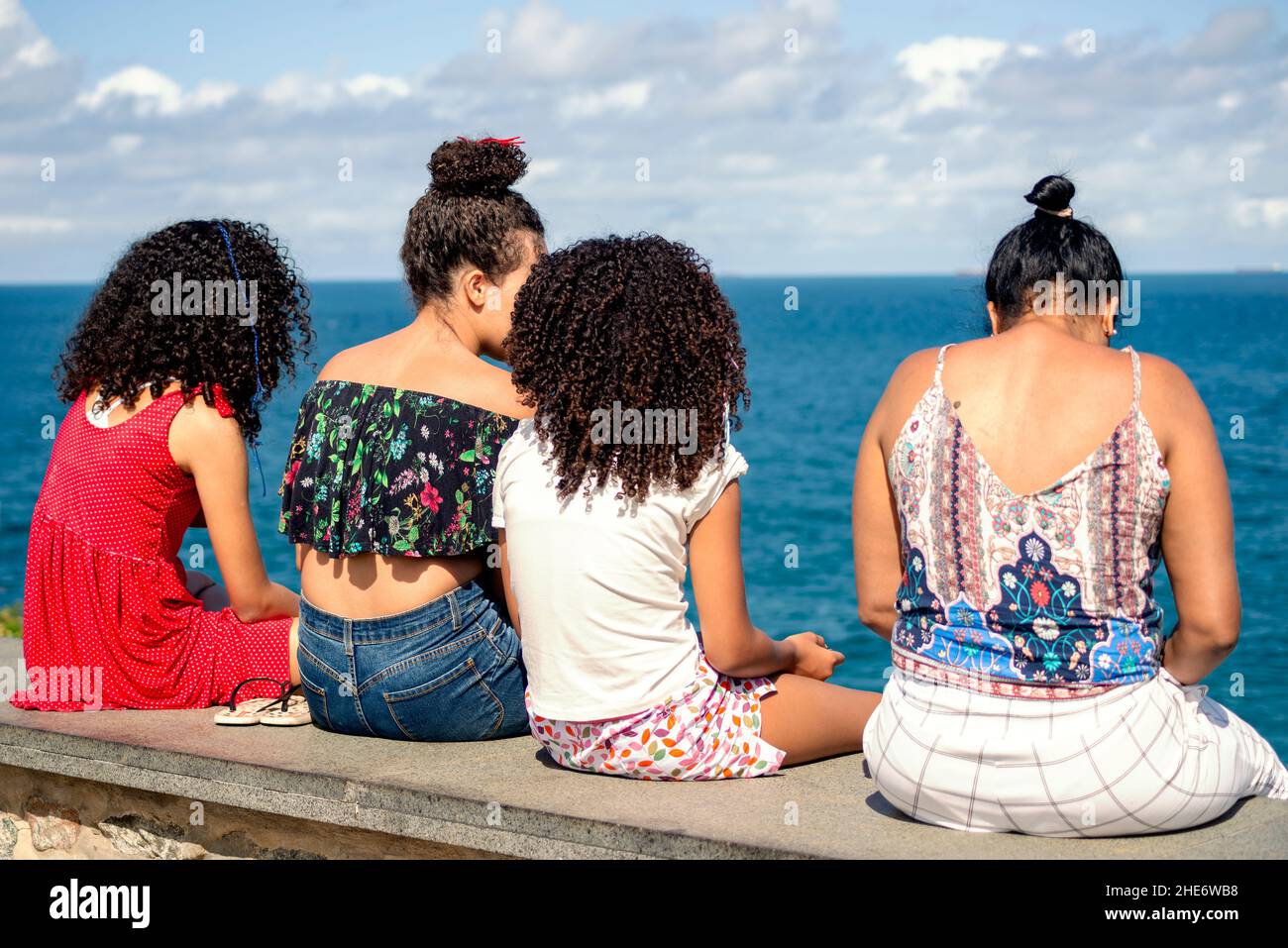Rücken von vier Frauen gegen Meer und Stadtlandschaft. Salvador Bahia Brasilien. Stockfoto