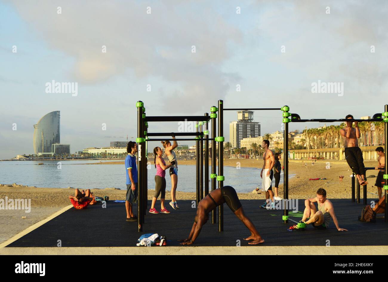 Junge Menschen trainieren am Morgen am Strand von Barceloneta, Barcelona Spanien Europa. Stockfoto