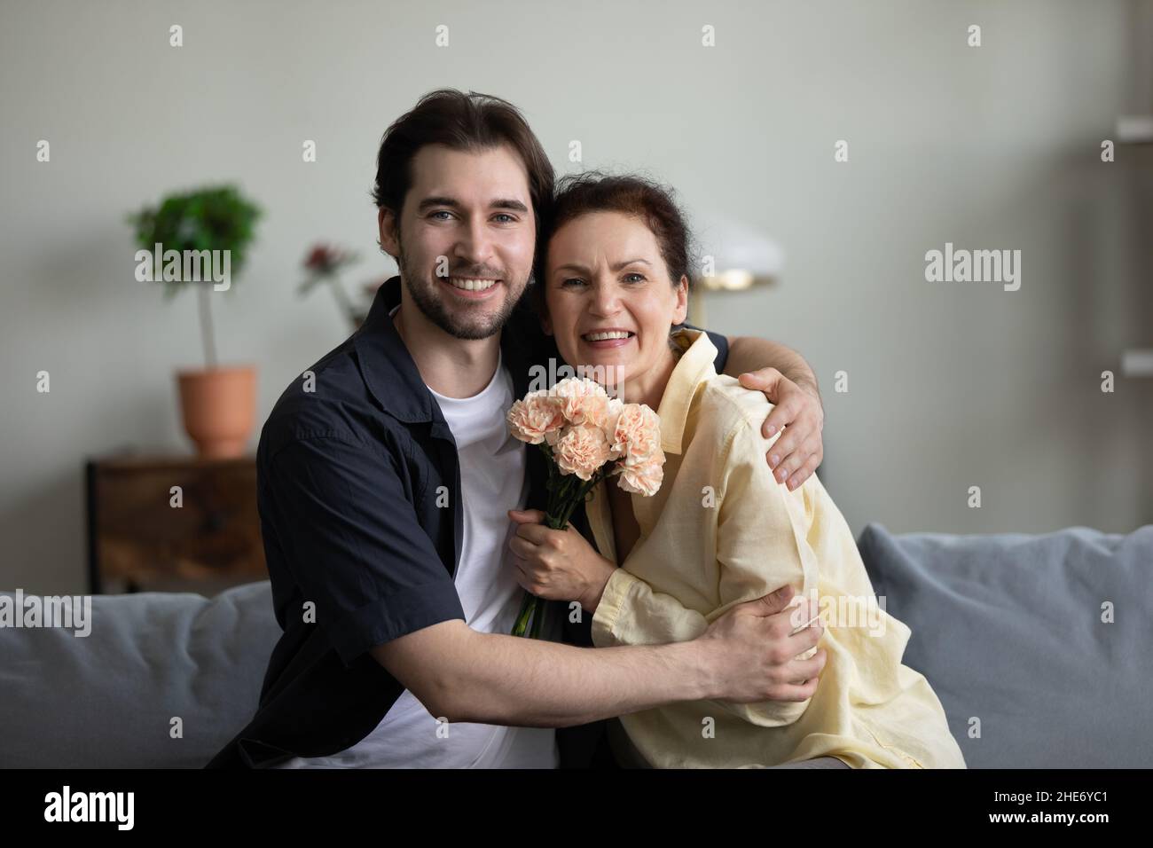 Glücklicher junger Sohn gratuliert der Mutter zum Geburtstag. Stockfoto