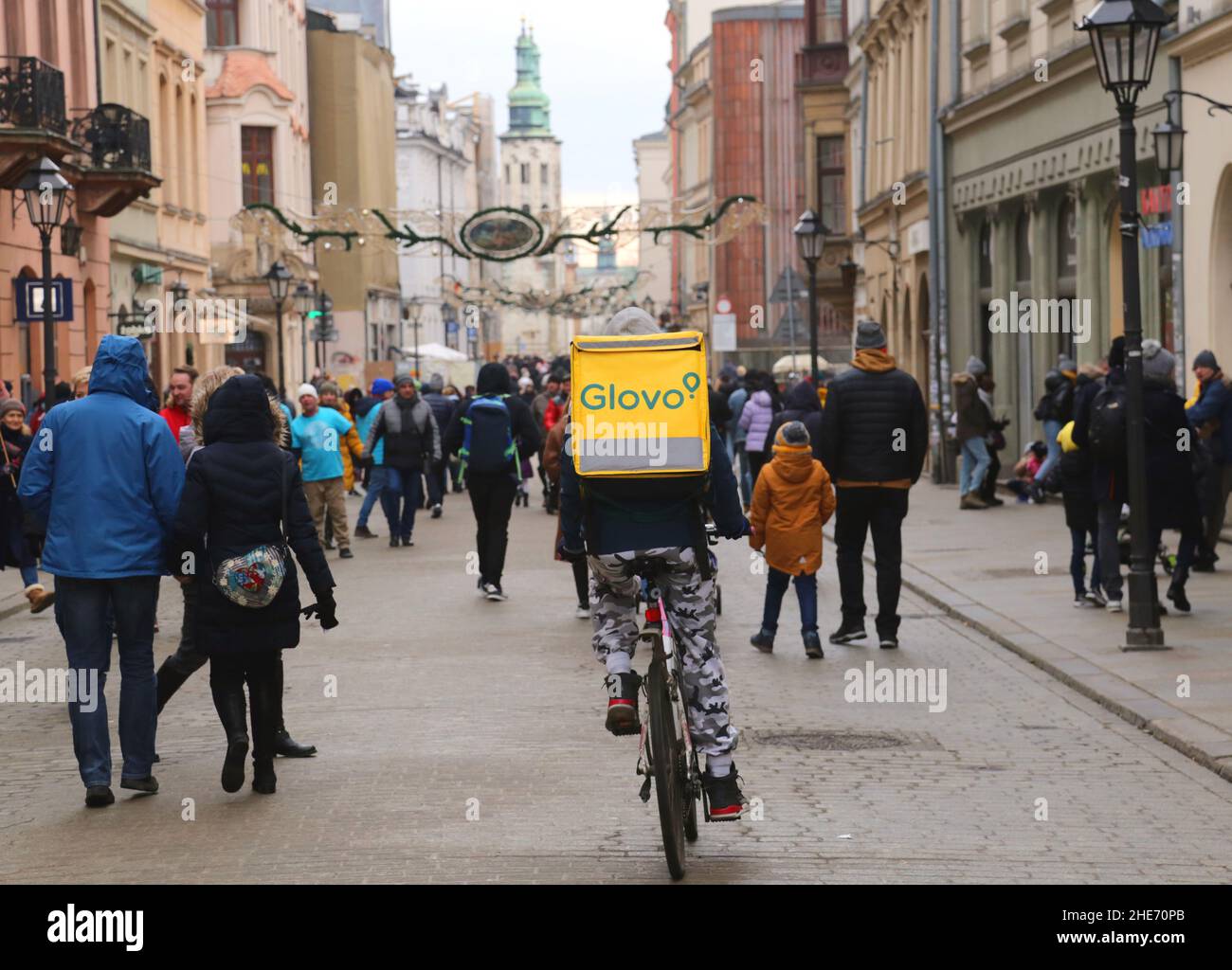 Krakau, Malopolska, Polen - 01.08.2022: Lebensmittellieferungskurier auf dem Fahrrad. Überfüllte Straße. Stockfoto