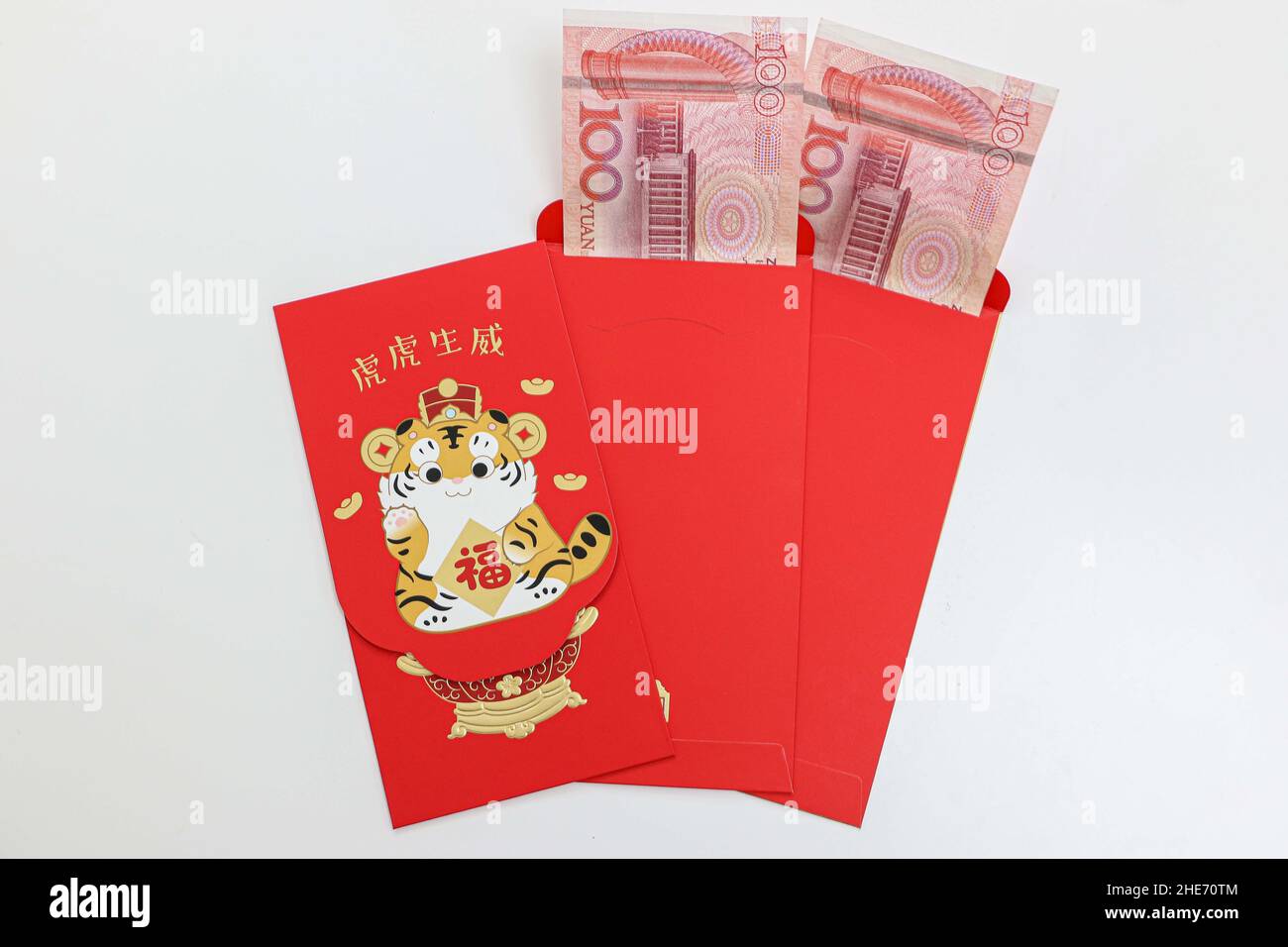 Chinesische Neujahrsgeld rote Umschläge mit 100 Yuan-Scheinen innen, ein Umschlag hat ein spezielles 2022-Tiger-Jahr-Design Stockfoto