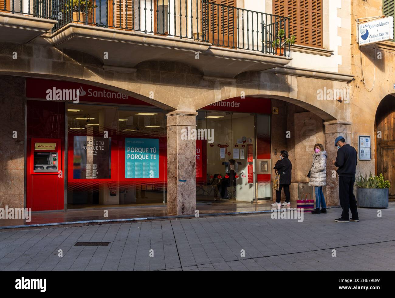 Llucmajor, Spanien; januar 07 2022: Zweigstelle der Banco Santander, in der mallorquinischen Stadt L warten Leute, die Schlange stehen und Masken tragen Stockfoto