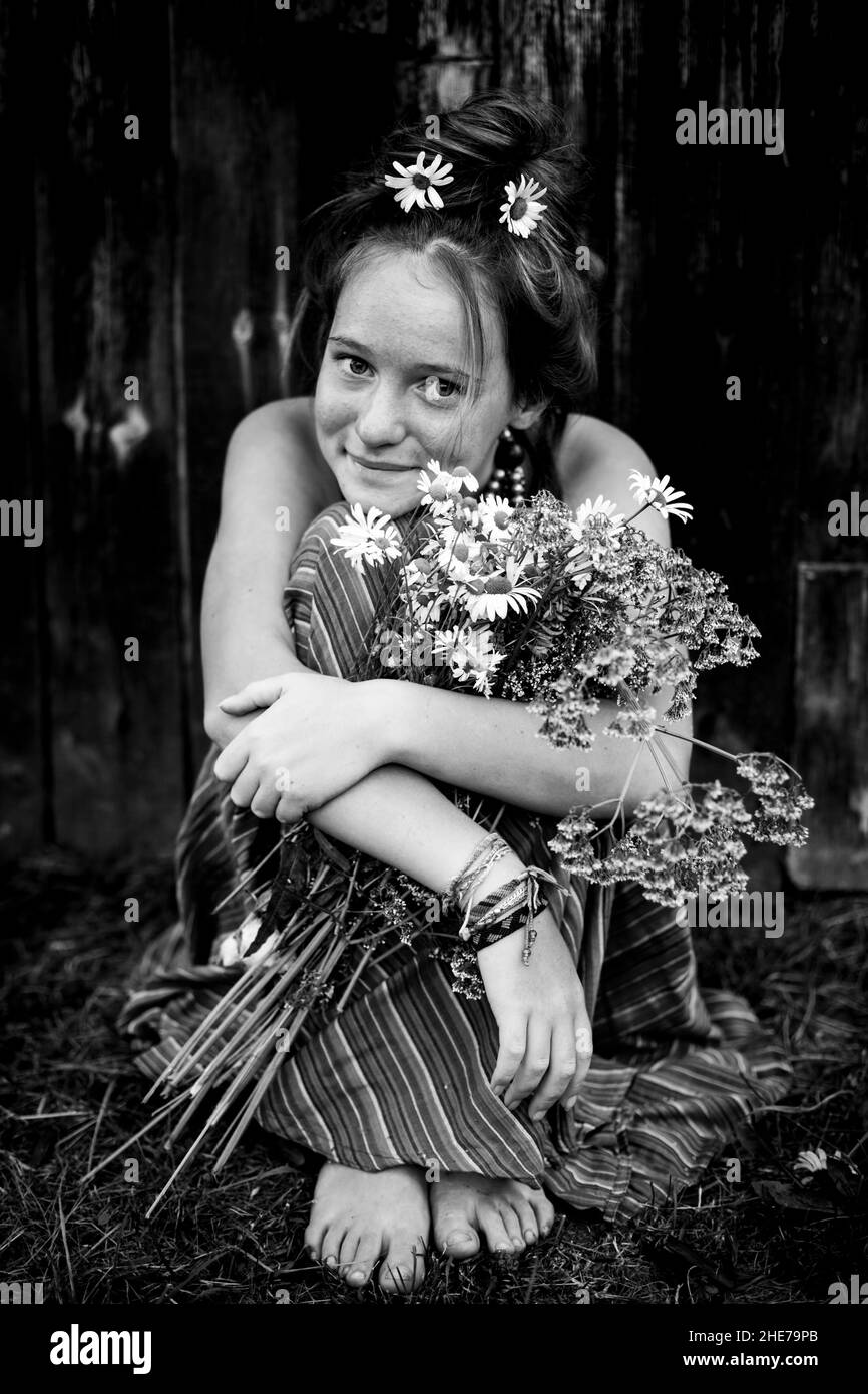 Schönes Landmädchen mit Gänseblümchen und einem Korb. Schwarzweiß-Foto. Stockfoto