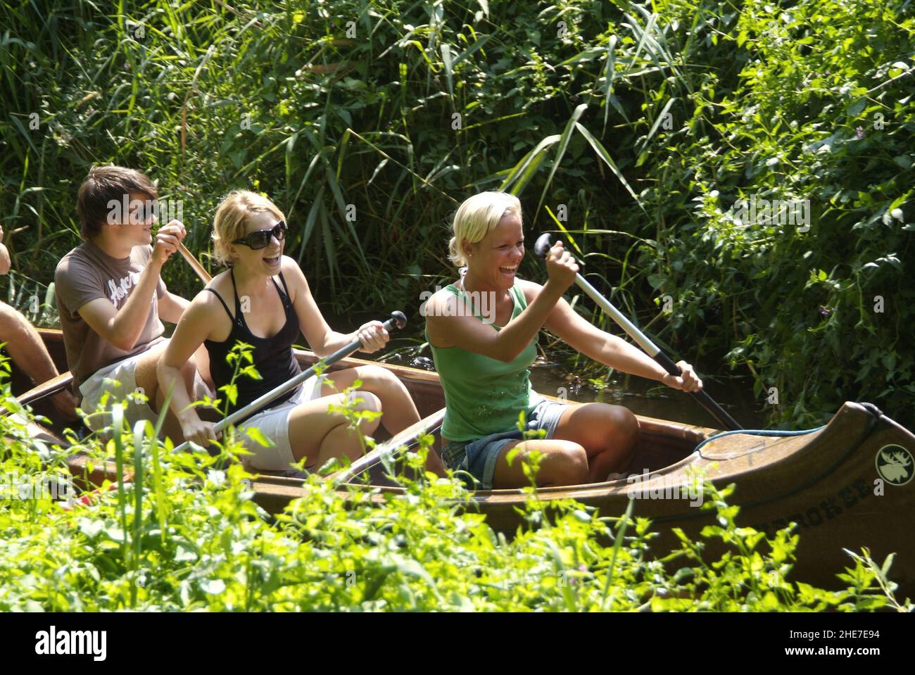 Jugendliche im Kanu paddeln durch enges Gewässer im Landkreis Celle, Niedersachsen, Deutschland, Europa | Junge Gruppe von Menschen, die auf einem kleinen Br Stockfoto
