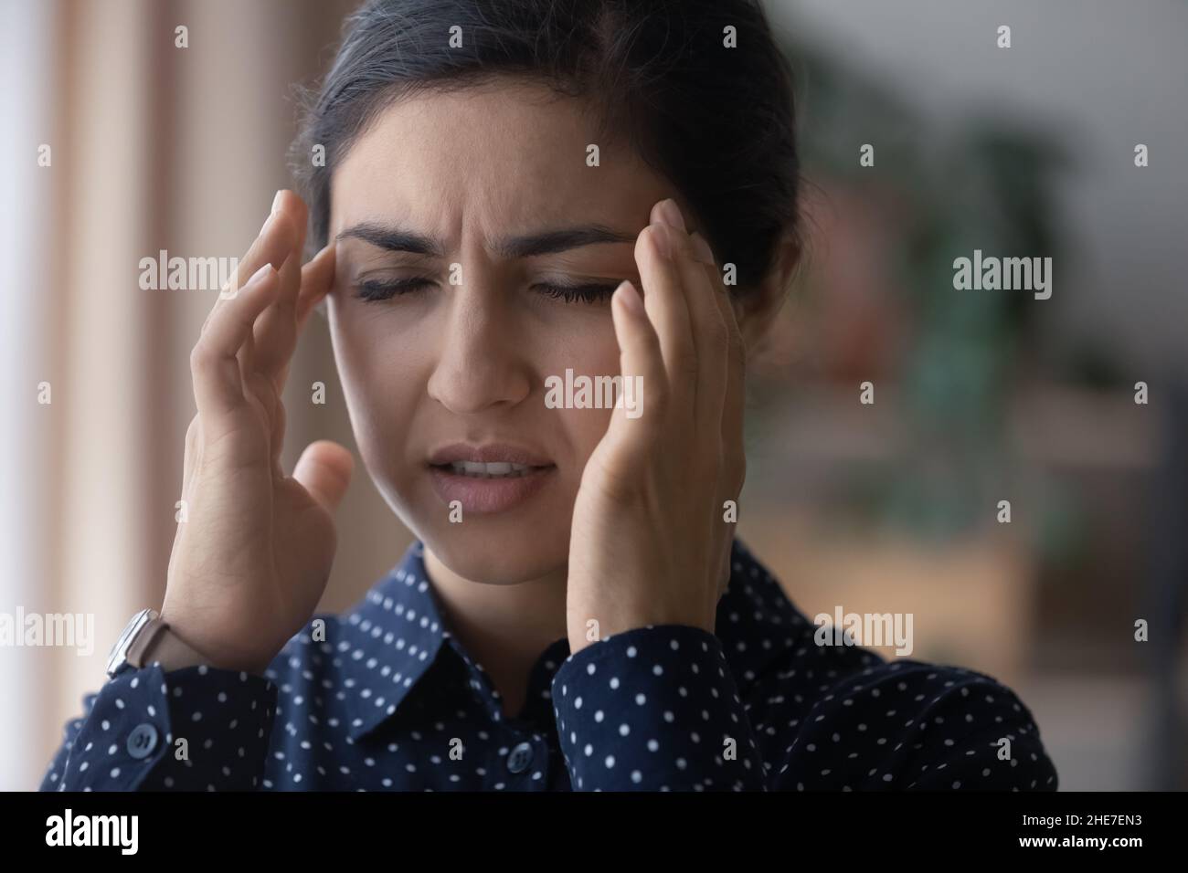 Unglücklich verärgert junge indische Frau, die unter Kopfschmerzen leidet Stockfoto