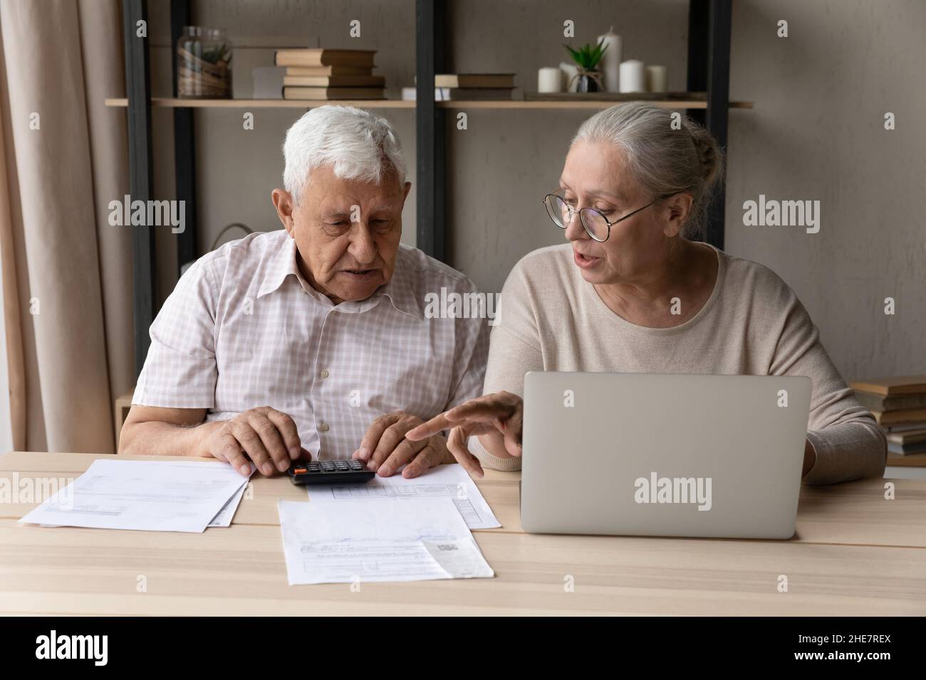 Konzentriertes Paar mittleren Alters, das das Haushaltsbudget verwaltet. Stockfoto