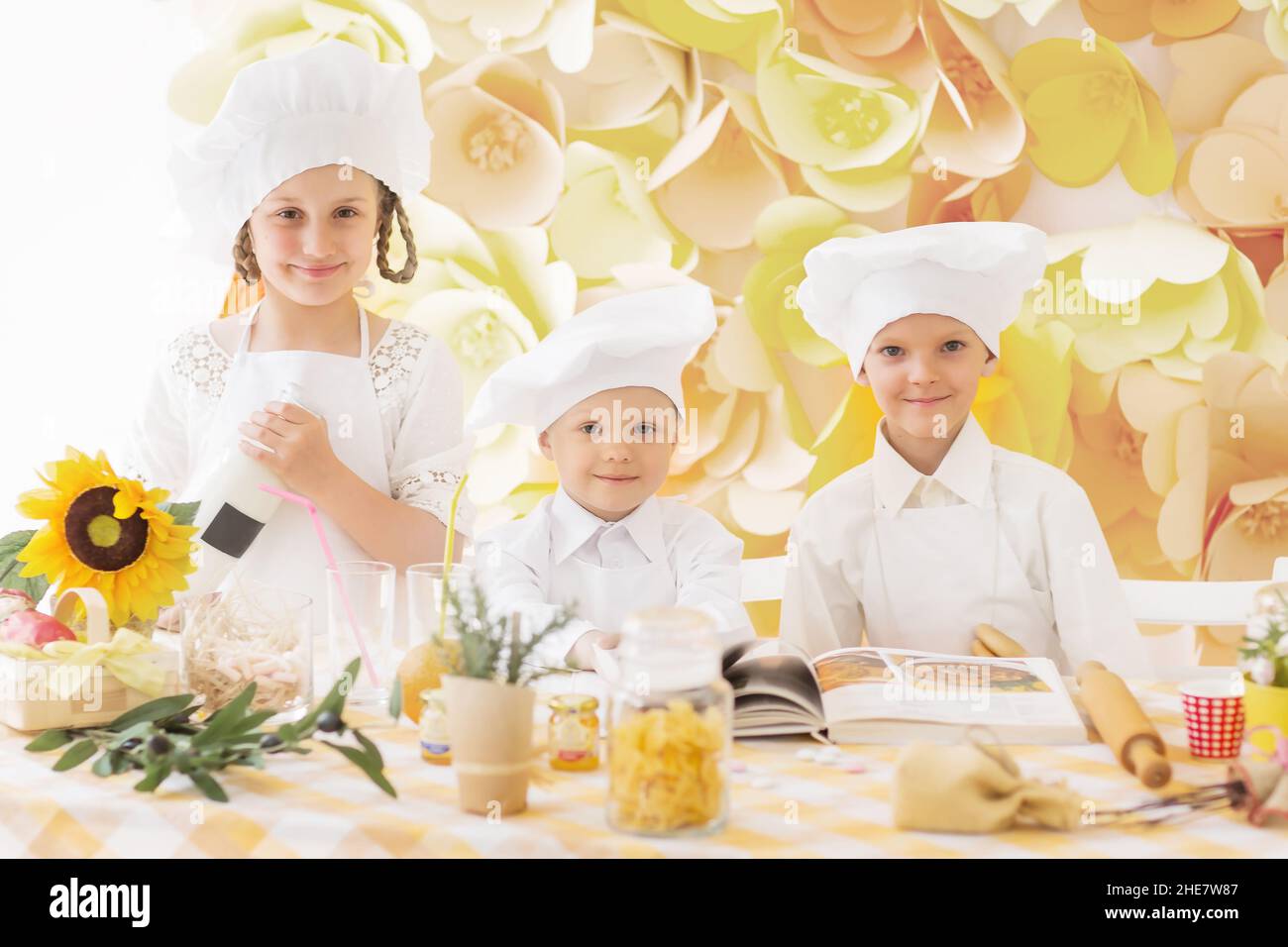 Glückliche Kinder in Form einer Küchenchef leckere Mahlzeiten zubereiten Stockfoto