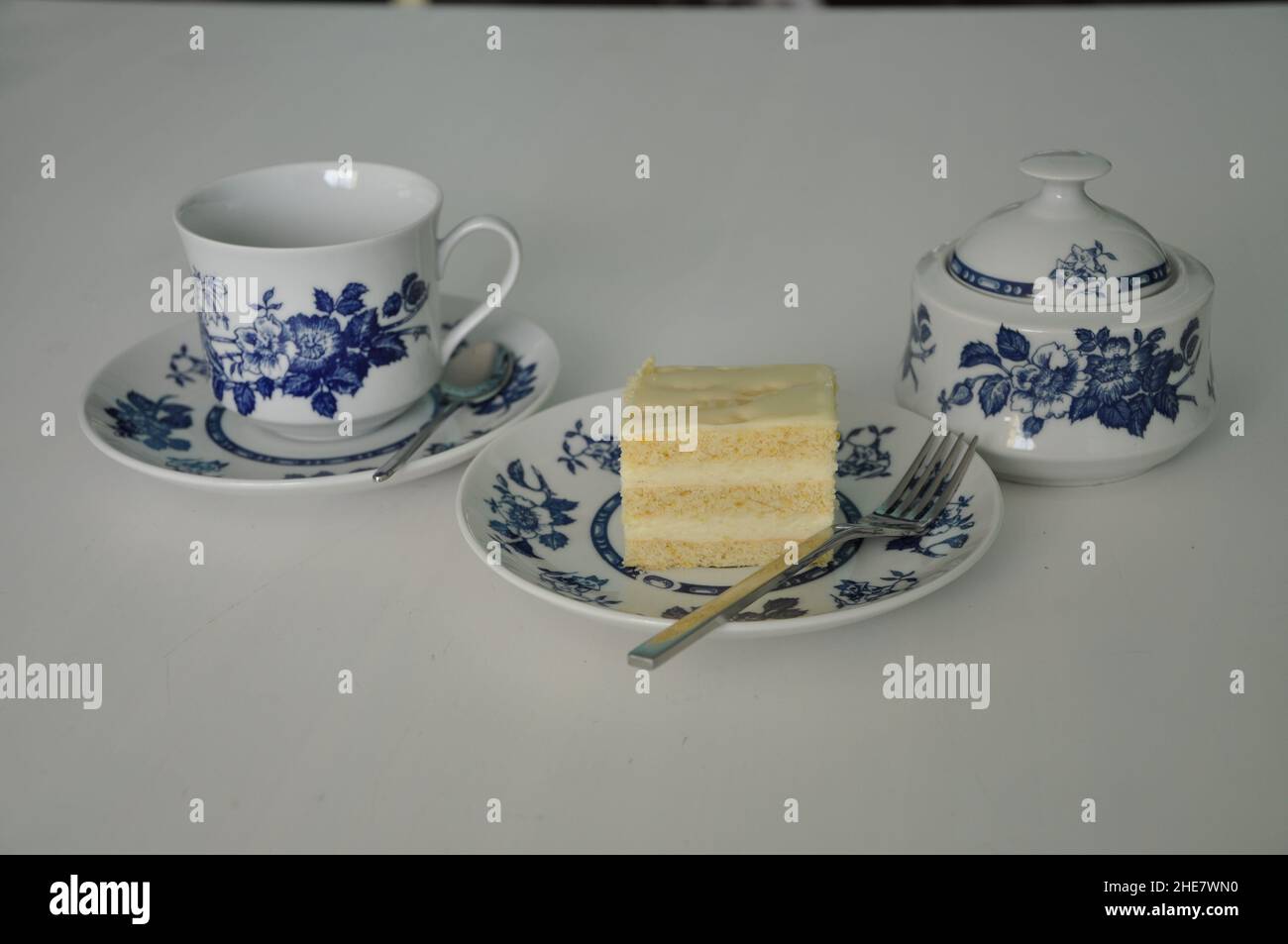Feines Porzellanset für Kaffee-Tee und Käsekuchen auf Teller. Tee im Stil der alten Schule am Nachmittag mit Kuchen, süßen traditionellen Tisch, Käsekuchen sug Stockfoto