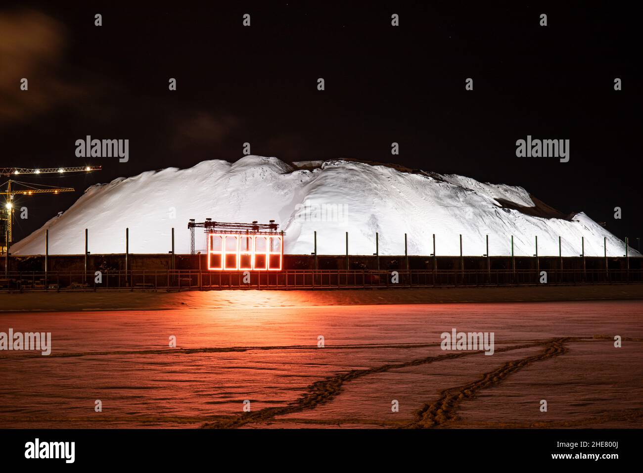 HAPPI. Lichtkunst-Installation von Jari Vuorinen beim Lux Helsinki Light Art Festival. Beleuchteter schneebedeckter Kohlebestand in Hanasaari. Stockfoto