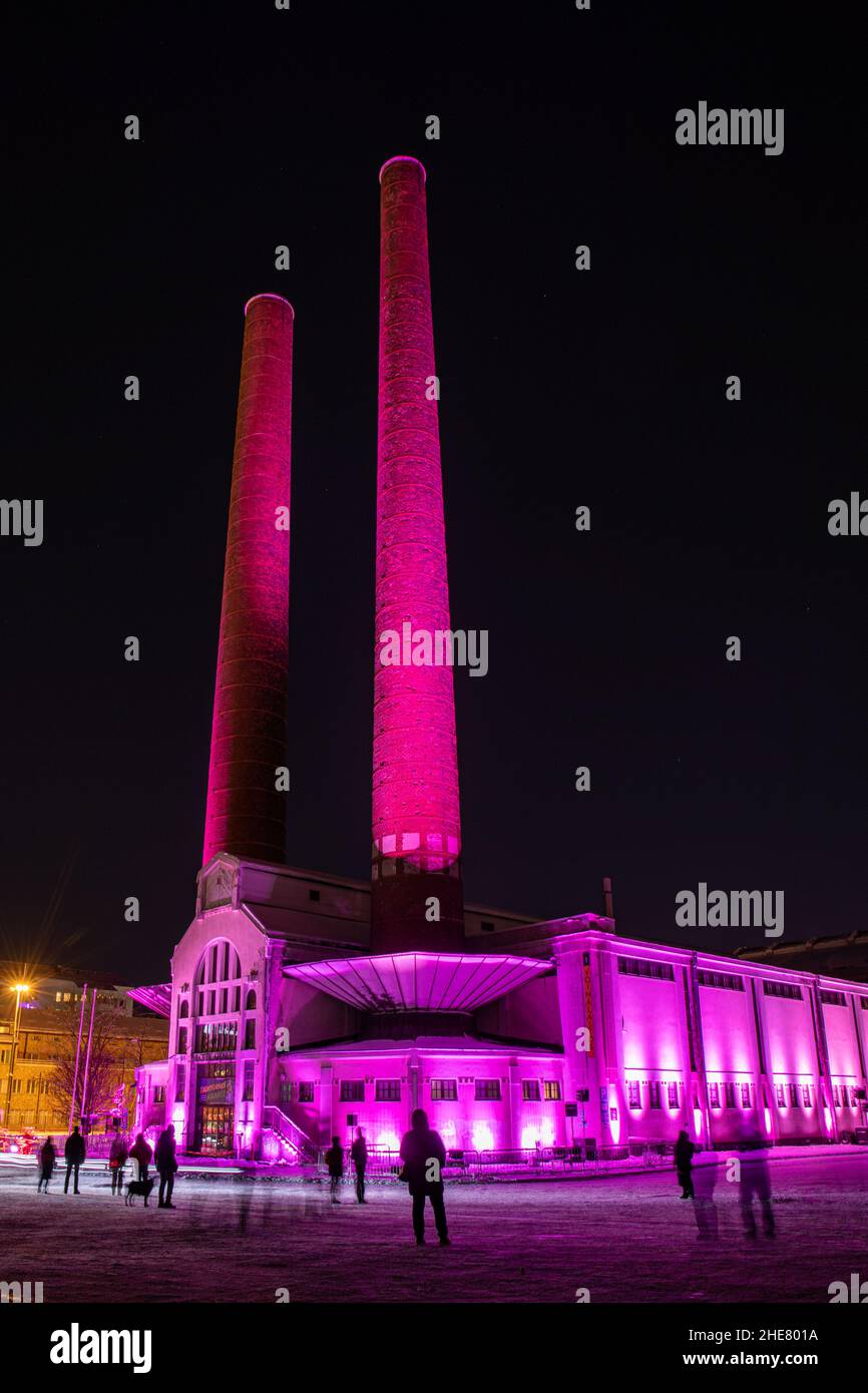 Pink Caravan. Lichtkunstinstallation von Ainu Palmu. Kattilahalli mit hohen Kaminen, die während des Lux Helsinki Light Art Festival in Pink erstrahlt. Stockfoto