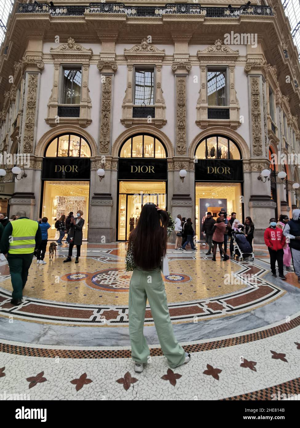 Die vertikale Aufnahme eines unbekannten Mädchens beobachtet ein weltberühmtes Dior-Modegeschäft in Mailand, Italien Stockfoto