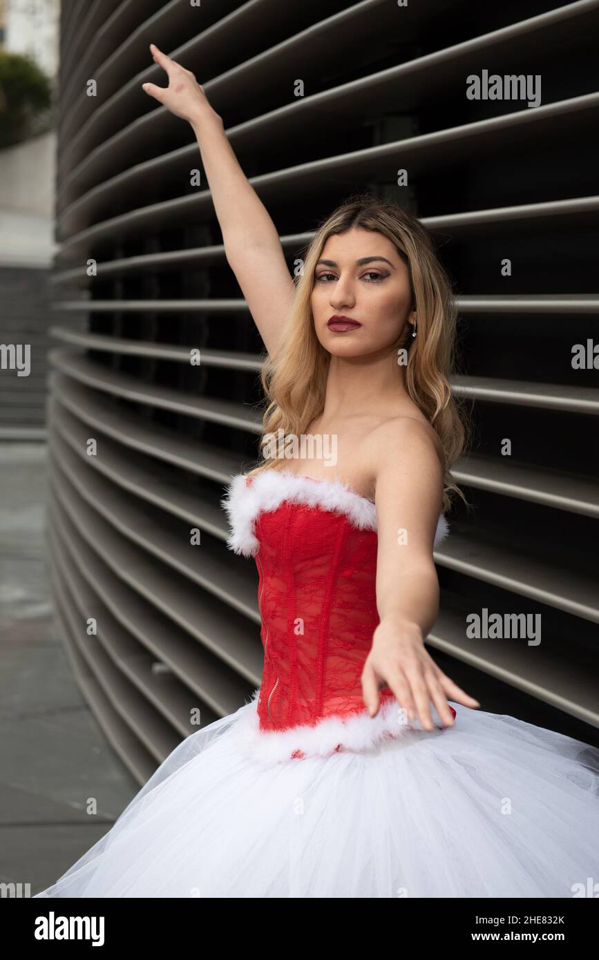 Ballerina trägt High Heels und weihnachtskleid posiert im Freien Stockfoto