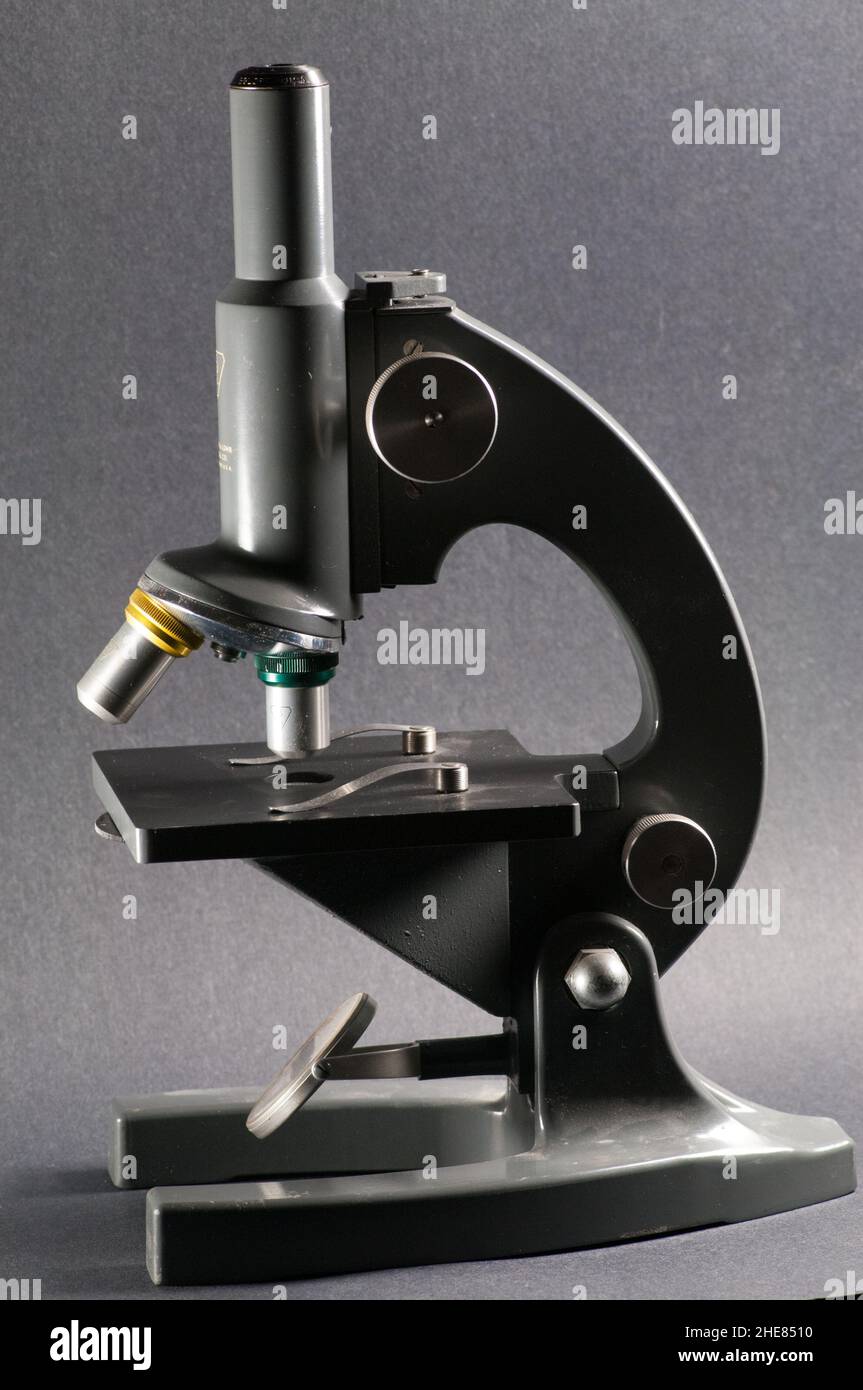 Altes Bausch + Lomb Mikroskop vor grauem Hintergrund. Stockfoto