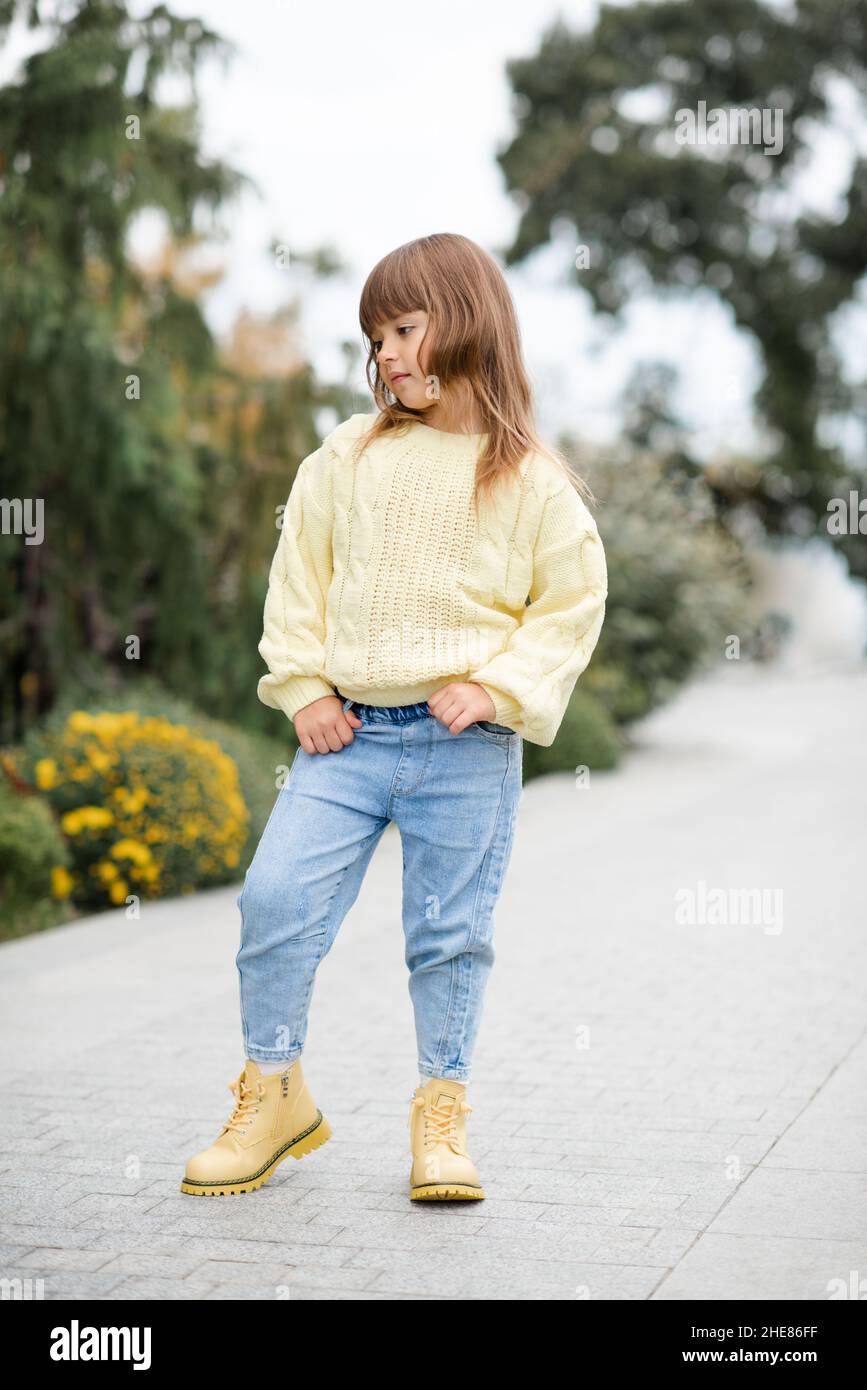Stilvolle Kinder Mädchen 5-6 Jahre alt tragen trendy lässig Pullover und Jeans  Hosen zu Fuß im Park im Freien. Frühling. Kleines Kind über Natur Frühling  backgro Stockfotografie - Alamy