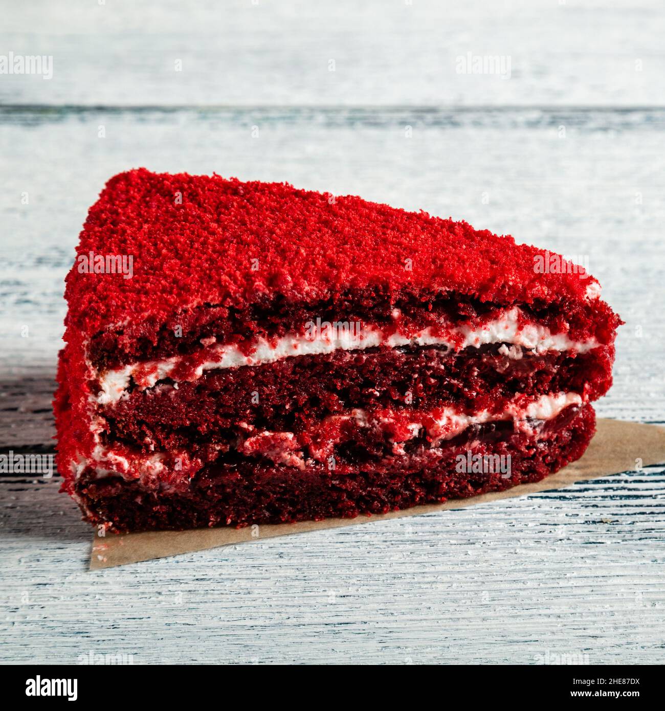 Ein Stück roter Kuchen auf einem hölzernen Hintergrund. Alte Bretter. Stockfoto