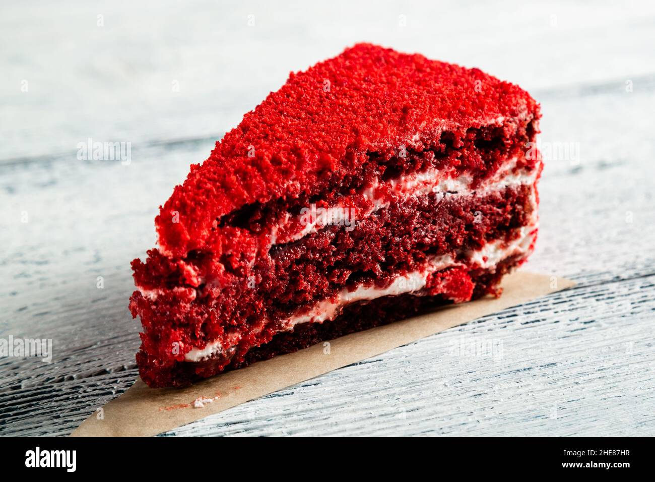 Ein Stück roter Kuchen auf einem Holzhintergrund. Alte Bretter. Stockfoto