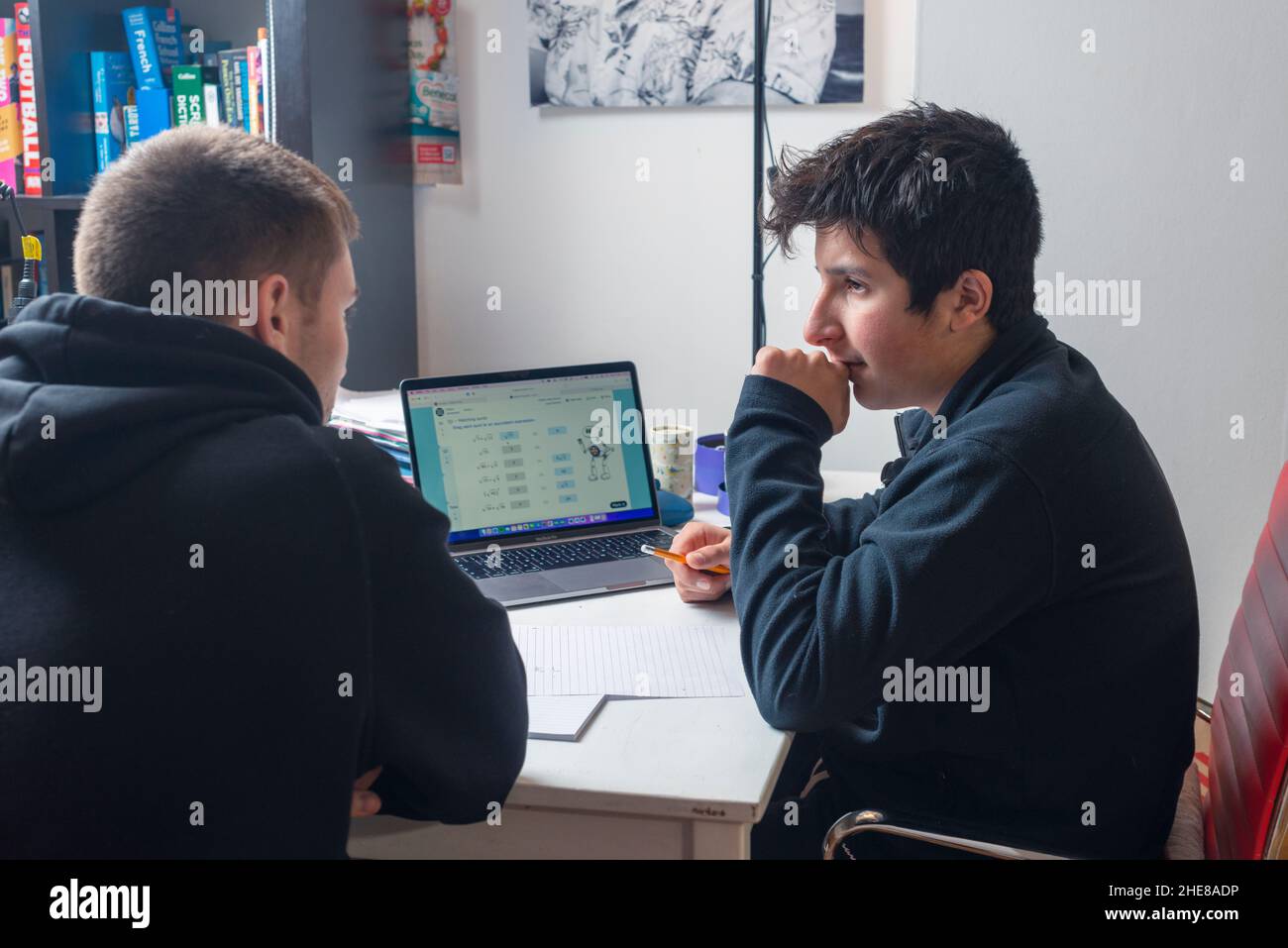 Junger Tutor hilft bei der Mathematikrevision Stockfoto