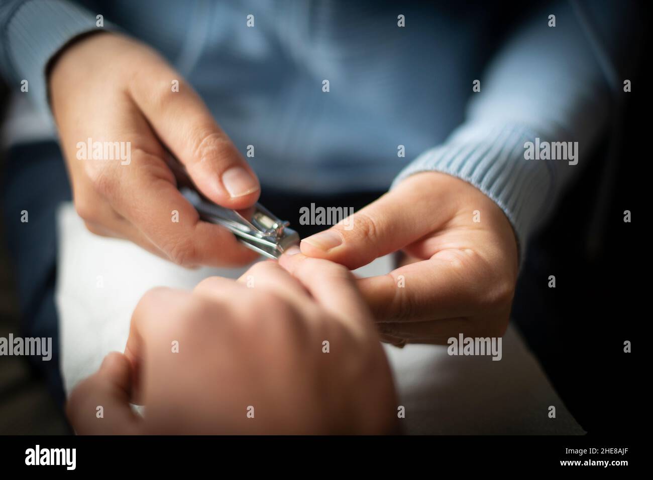 Frau schneidet Personen Fingernägel mit Nagelknipser-close-up Stockfoto
