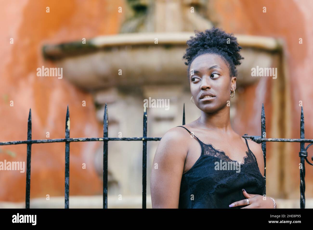 Ablenkende afrikanerin mit einem eleganten schwarzen Tank-Top im Freien Stockfoto