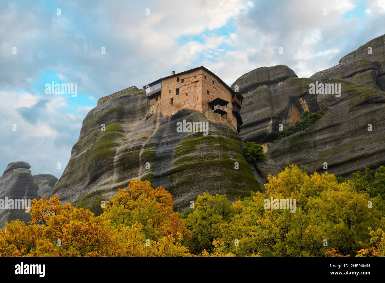 Heiliger Monastery of St. Nichola Anapafsasat Meteora, Griechenland unter nebligen, bewölkten Himmel mit Blättern, die im Herbst die Herbstfarben färben. Stockfoto