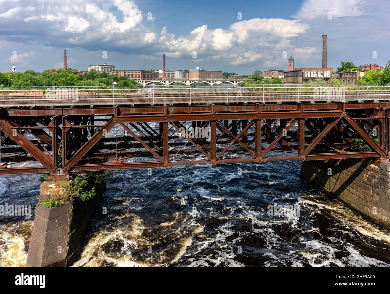 Blick auf eine Eisenbahnbrücke, die den Merrimack River überquert, der durch die Mühlenstadt Lawrence, Massachusetts, fließt. Stockfoto