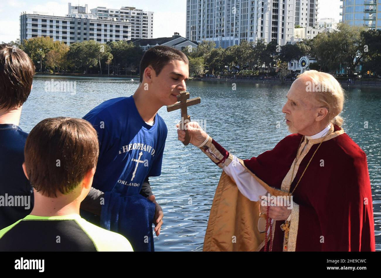 Orlando, Usa. 09th Januar 2022. Isaac Abdelmessih küsst das Kreuz, das von Fr. John Hamatie, nachdem er es vom Eola-See während des jährlichen Epiphany-Kreuztauchgangs der St. George Orthodoxen Kirche in der Innenstadt von Orlando zurückholen durfte. Die Feier ehrt die Taufe Jesu Christi und es heißt, dass die Person, die das Kreuz abholt, für den Rest des Jahres Glück erhalten wird. (Foto von Paul Hennessy/SOPA Images/Sipa USA) Quelle: SIPA USA/Alamy Live News Stockfoto